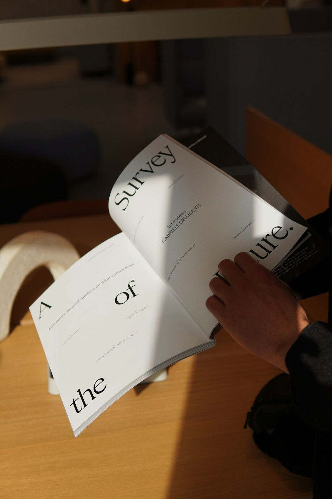 Researcher reviewing printed survey questionnaires and statistical charts at a desk