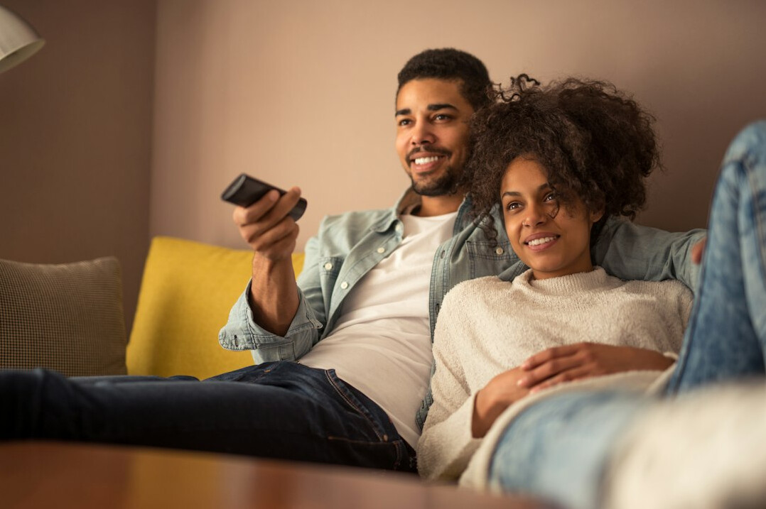 Diverse group of German adults watching television together in a living room